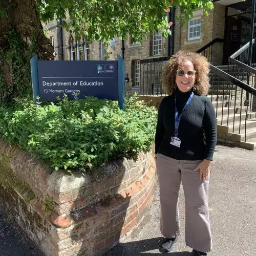 Dr Isar Godreau next to Department of Education sign, Oxford University