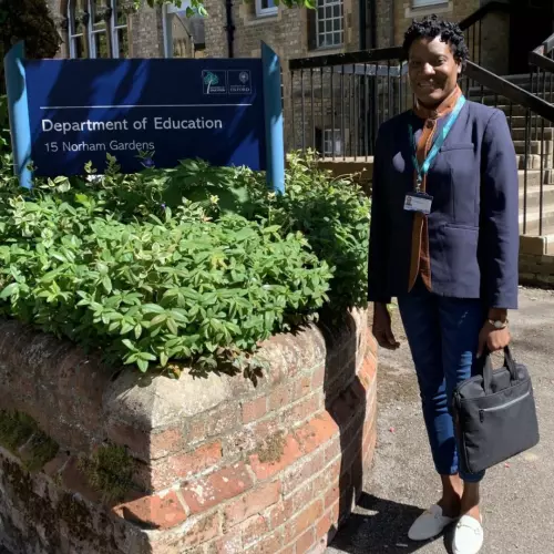 Dr Shenika McFarlane Morris by the sign at the Department of Education