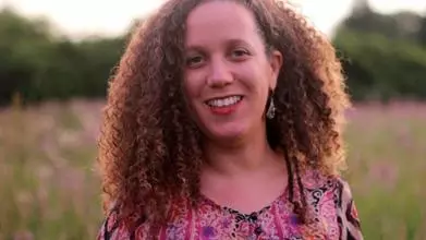 Isar Godreau smiling in a field